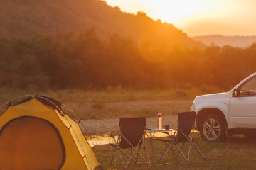 Wall Mural - camping at beach of mountain river. suv car. yellow tent. camp table and chairs