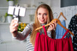 © artiemedvedev - Fashion blogger woman in jeans and turtleneck showing casual colorful shirts on camera. Stylist influencer girl showing trendy clothes filming vlog episode for her channel. Opinion leader sets trends.