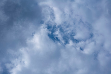 Blue sky seen from the gap between the approaching clouds in midsummer