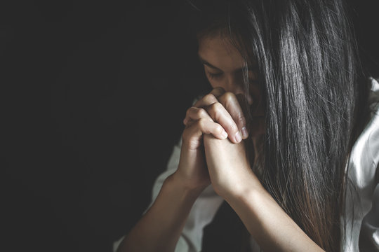 Young woman praying with  hand,  prayer concept for faith, spirituality and religion