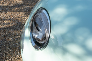 Detailed view of a new style high-powered headlight seen on a new, super-mini styled car. Seen parked on a private driveway.