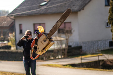 Wall Mural - Chainsaw in air during throwing contest