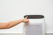 woman is turning on air purifier in home