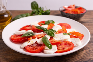 Wall Mural - Italian Caprese dish with mozzarella cheese, fresh tomatoes, basil and extra virgin olive oil. Italian food, ideas for fast lunch, summer lunch.