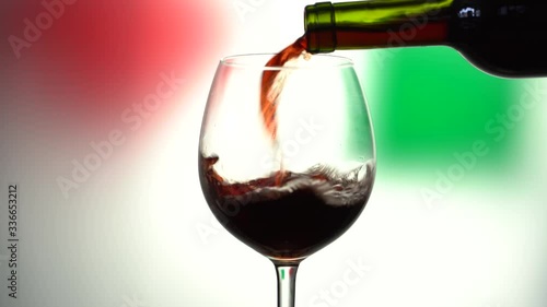 Photo pouring red wine glass from the bottle