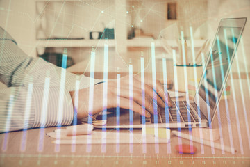 Double exposure of stock market graph with man working on laptop on background. Concept of financial analysis.