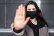 © Nickolay - Young woman wearing face mask. Handsome woman in black hoodie wear black medical mask. Pandemic coronavirus covid-19 quarantine period concept.