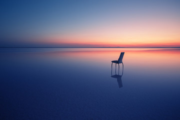 Wall Mural - chair among smooth water of lake at sunset