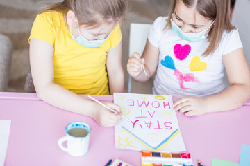 Girls drawing together at home during quarantine in sterile masks. Childhood games, drawing arts, stay at home concept