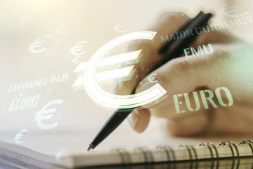 Creative EURO symbols illustration and woman hand writing in notebook on background, forex and currency concept. Multiexposure