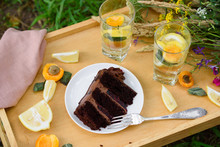 Summer Picnic, A Slice Of Chocolate Cake And A Cooling Lemonade With Wild Flowers