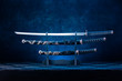 Three swords on stand, katana blade exposed, blue