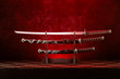 Three swords on stand, katana blade exposed, red