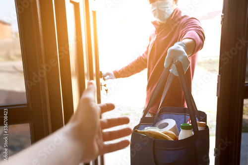 Fotografía The delivery man gives the bag from grocery store to the woman to her home
