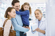 © zinkevych - Blonde professional female pharmacist aiding young family