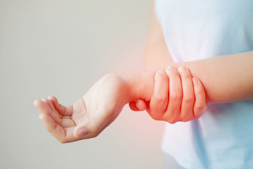 Closeup of woman arms holding his painful palm caused by prolonged work office syndrome. rheumatoid arthritis, gout or sprain weakness and tingling. Health care concept. 