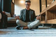 © Jacob Lund - Businessman doing relaxation yoga in office lounge