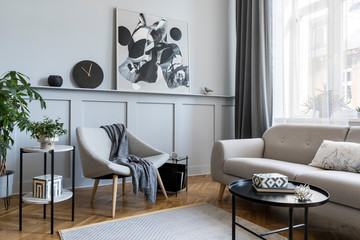 Wall Mural - Stylish scandinavian home interior of living room with design gray sofa, armchair, marble stool, black coffee table, modern paintings, decoration, plant and elegant personal accessories in home decor.