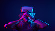 © nuclear_lily - Woman is using virtual reality headset. Neon light studio portrait. Image with glitch effect.