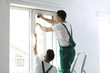 © New Africa - Professional workers tinting window with foil indoors