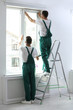 © New Africa - Professional workers tinting window with foil indoors