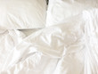 © tassita - Unmade bed; wrinkled pillowcases, bed sheet and duvet