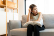 © structuresxx - Depression and sadness concept,Young asian woman covering her face sitting on sofa in home.
