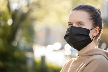 Virus mask Asian girl travel wearing face protection in prevention for coronavirus. Girl walking on the street with green tree background