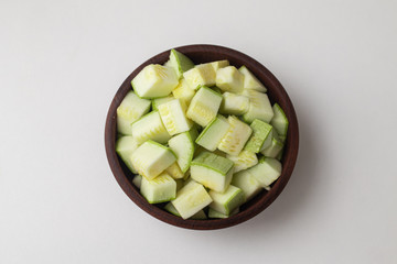 Wall Mural - Diced Zucchini into a wooden bowl