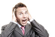 © PeskyMonkey - Nervous businessman holding his head looking at the camera screaming with a frightened expression