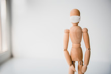 Wooden Mannequin In Medical Mask On White Background. Concept Quarantine Photo.
