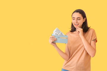 Wall Mural - Young woman with wallet on color background