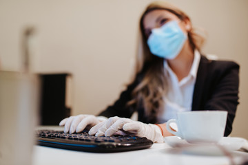 Young attractive caucasian businesswoman with mask and gloves in office. COVID - 19 virus protection