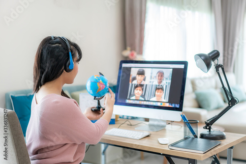 Fotomural Asian woman teacher teaching geography via video conference e-learning and cheerful elementary school student looking at globe, Homeschooling and distance learning ,online ,education and internet