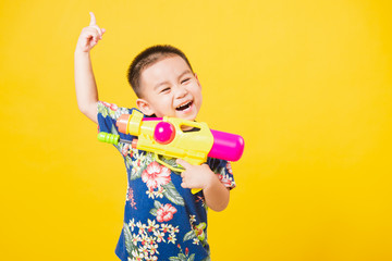 little children boy so happy in Songkran festival day holding water gun