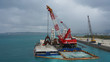 © Artem - Floating crane platform with a huge bucket extracts sand from the bottom of the Pacific Ocean.a huge crane extracts white sand from the ocean off the coast of Okinawa.