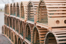Stack Of Rounded Wooden Lobster Cages With Green Nets.