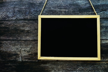 Wall Mural - Empty black board on dark wooden wall texture background