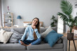 © BestForYou - Smiling woman using mobile on the sofa at home. Online chat.