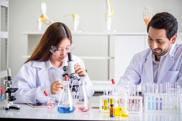 Wall Mural - attractive happiness scientist lab technician assistant analyzing sample in test tube at laboratory.