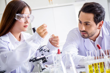 Wall Mural - attractive happiness scientist lab technician assistant analyzing sample in test tube at laboratory.