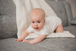 © Tina kids photo - Healthy baby boy lies on the sofa with a soft plaid. Baby's comfort at home