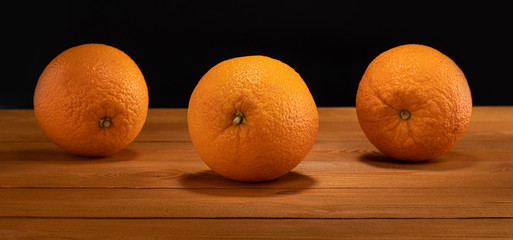 fresh oranges on the wooden table and black background