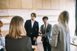 Group of business people in a meeting standing grouped in a office