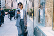 Smile young formal pretty businesswoman surfing smartphone on street