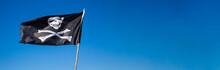 Pirate Flag, Black Flag With Skull And Crossbones On Blue Sky Background, Pirate Banner