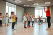 © Svitlana - Learning a new dance. Group of little boys and girls dancing while having choreography class in the dance studio. Dance teacher and children