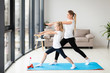 © FreepikCompany - Side view of mother exercising along with child at home