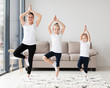 © FreepikCompany - Front view of mother with daughters at home exercising