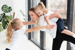 © FreepikCompany - Mother playing with daughters at home while working out